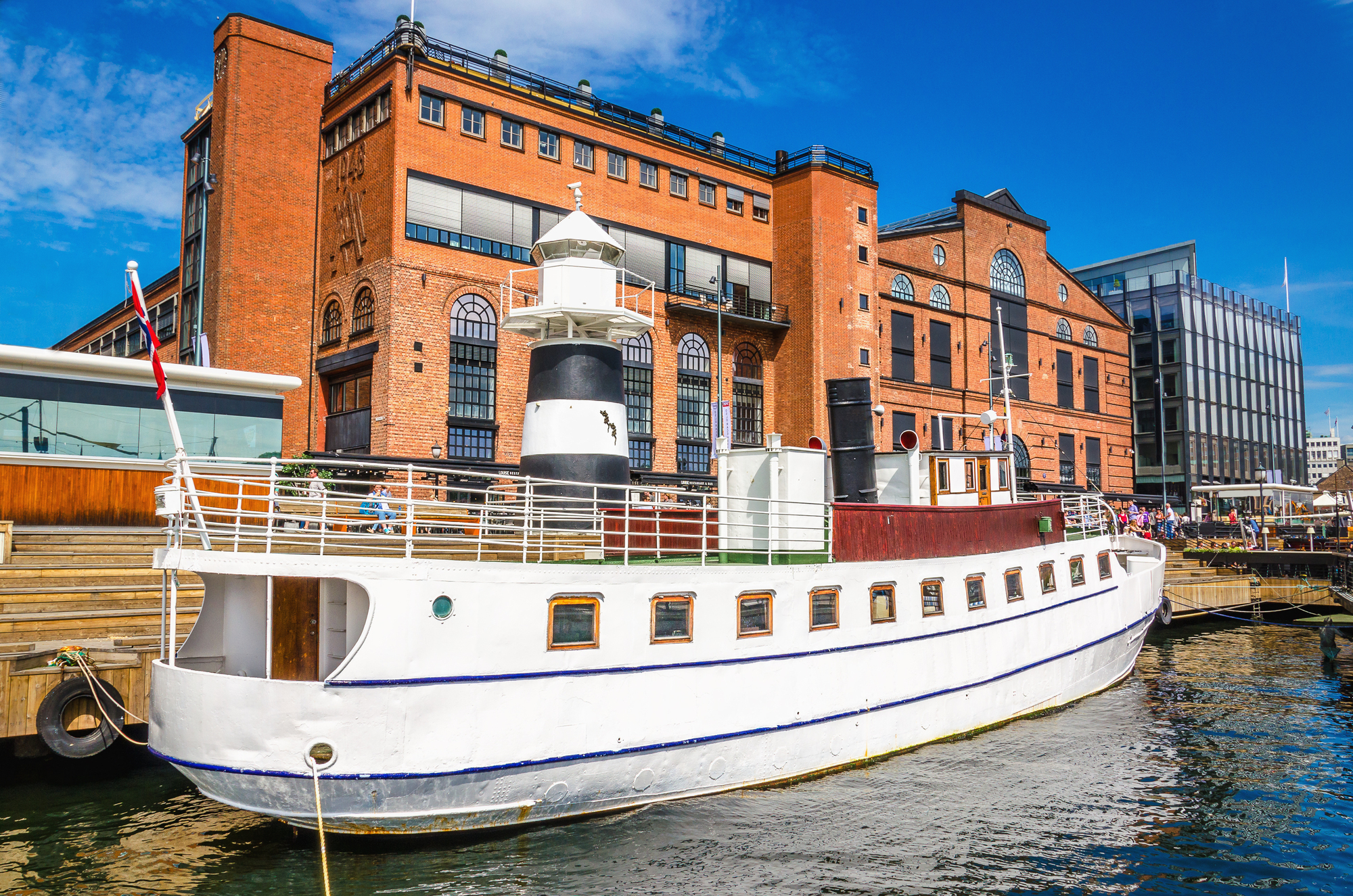 Del aeropuerto de Oslo al centro - guía de transporte 12 Aker Brygge en Oslo con un yate blanco en el puerto
