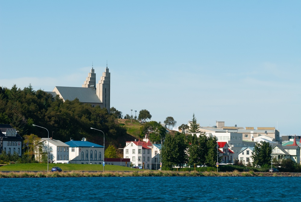 ¿Dónde alojarse en Islandia? Las 7 mejores zonas y buenos hoteles 15 Akureyri vista desde el otro lado del fiordo Eyjafjörður, con casas de colores junto al agua y la iglesia sobre la ciudad