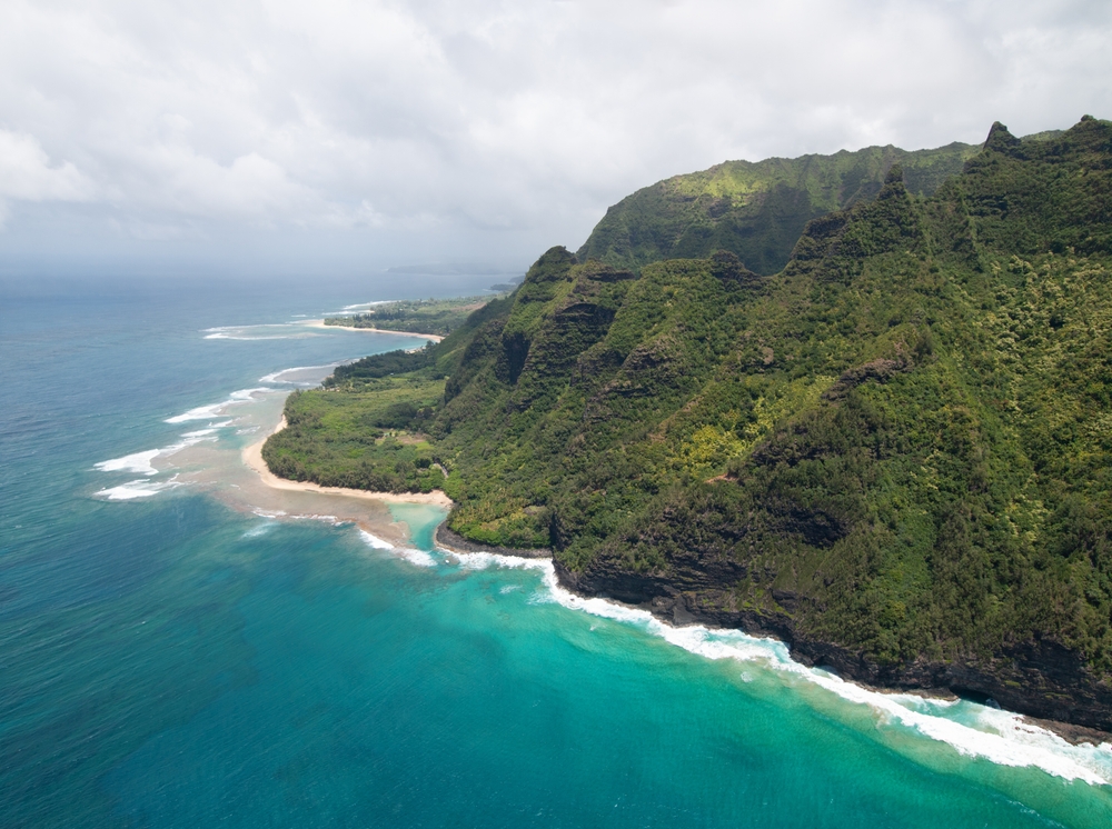 Vista aérea de la costa de Na Pali, en Kauai, con acantilados verdes escarpados y mar turquesa