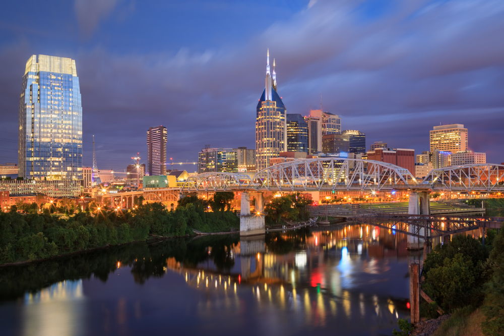 El perfil urbano de Nashville y el puente peatonal John Seigenthaler Pedestrian Bridge sobre el río Cumberland al amanecer