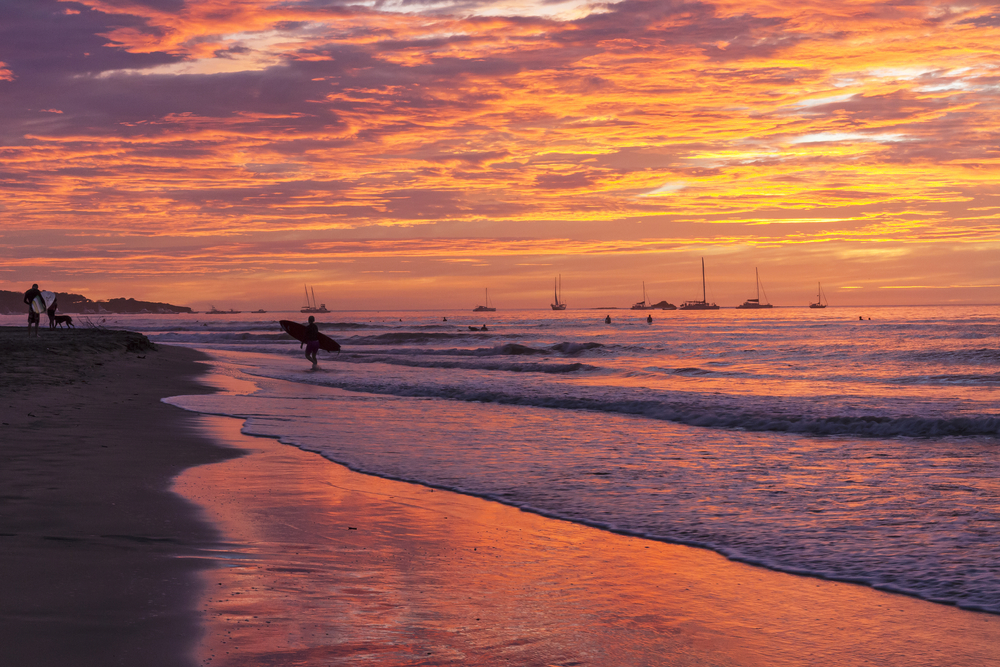 ¿Dónde alojarse en Costa Rica? Las 7 mejores zonas y buenos hoteles 13 Surfista en la playa de Tamarindo en Guanacaste al atardecer