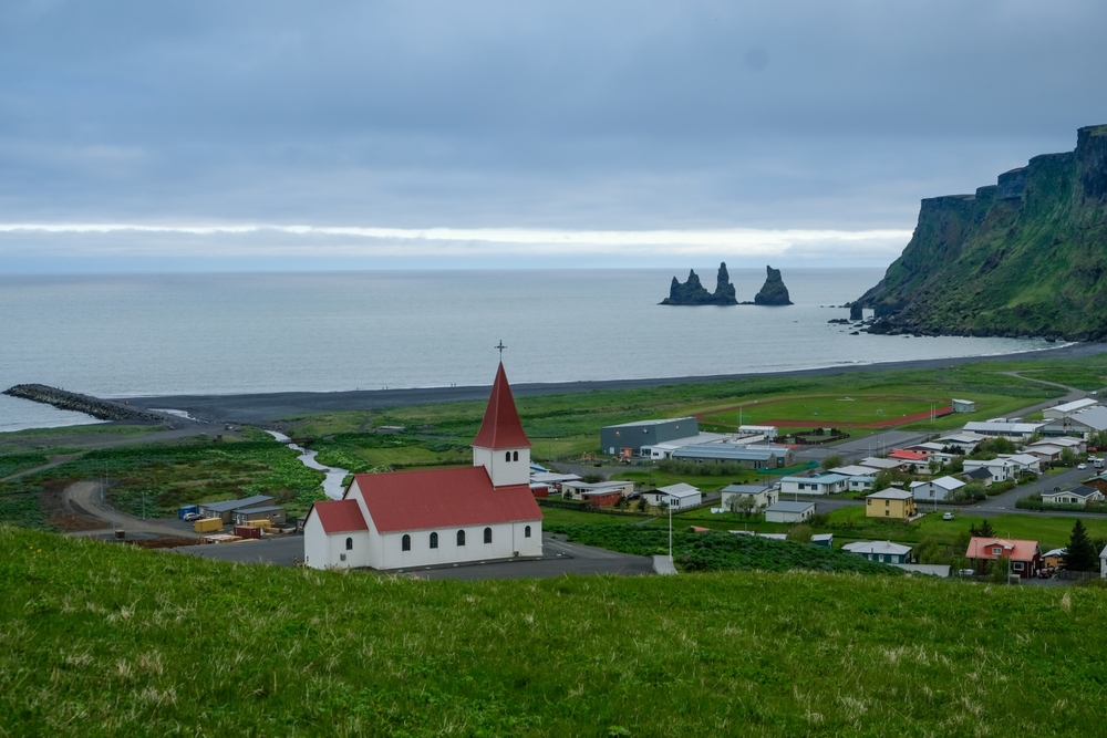 ¿Dónde alojarse en Islandia? Las 7 mejores zonas y buenos hoteles 12 Vík con su iglesia, la playa de arena negra y los farallones de Reynisdrangar en la costa sur de Islandia