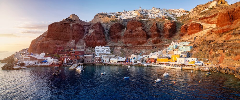 Qué ver en Santorini: 18 cosas que hacer, de la puesta de sol en Oia a las playas volcánicas 30 Ammoudi Bay con restaurantes y barcas de pesca a la luz del atardecer