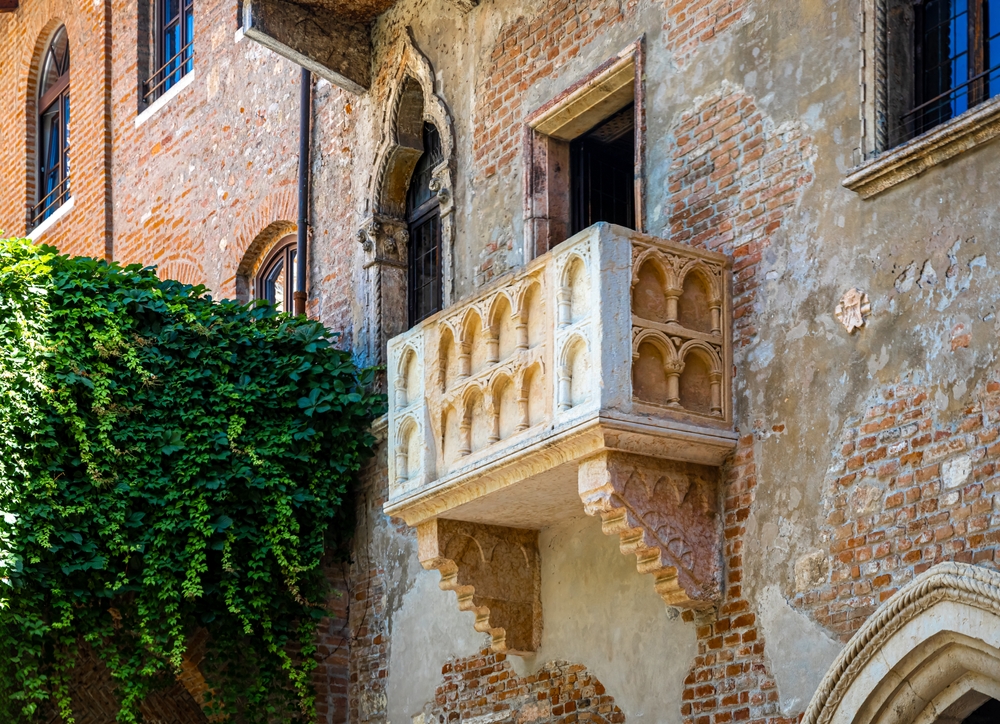 El balcón de Julieta en Verona con muros de piedra y hiedra