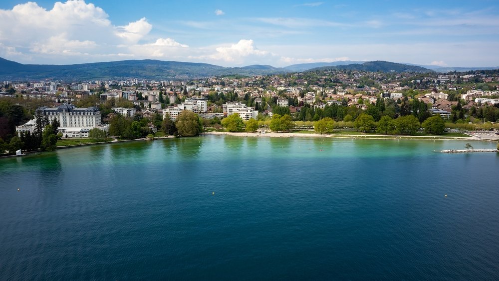 Vista aérea de Annecy y del lago turquesa Lac d'Annecy con las montañas al fondo
