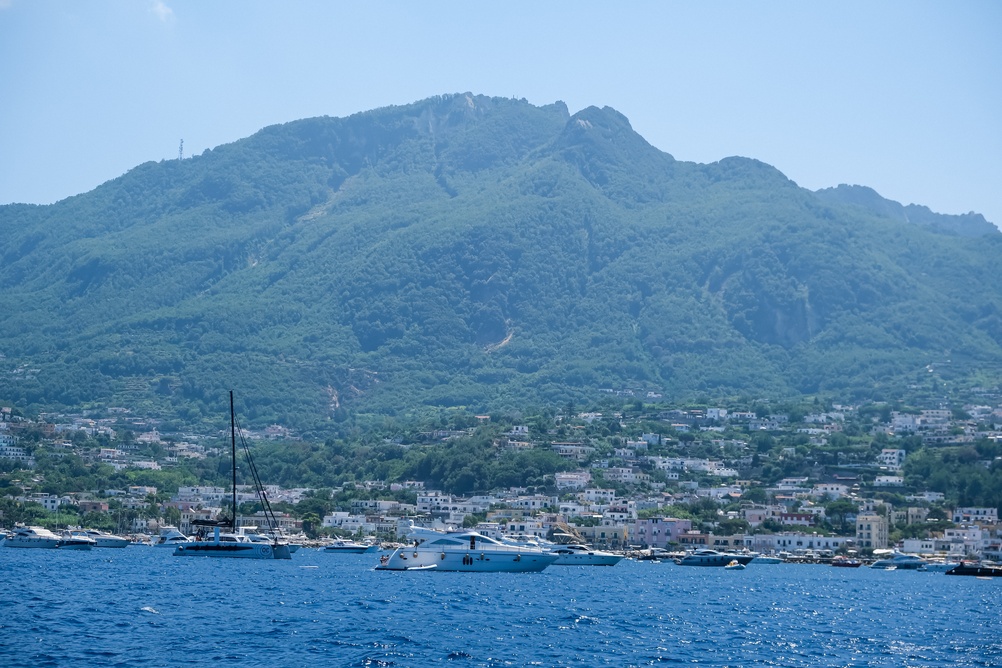 El monte Epomeo y un pueblo portuario de Ischia con barcos fondeados en primer plano