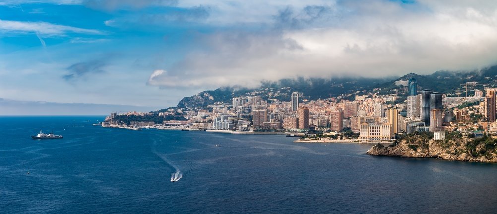 Vista aérea de Mónaco con Montecarlo, el Puerto Hércules y la playa de Larvotto
