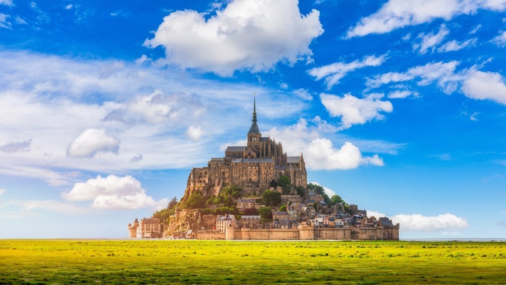 Dónde alojarse en Normandía: el Mont-Saint-Michel con la abadía sobre la isla rocosa en la bahía
