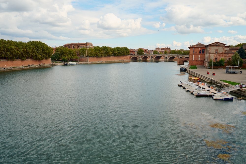 El río Garona y el puente Pont Neuf en Toulouse, con las casas de ladrillo rosado a lo largo del muelle