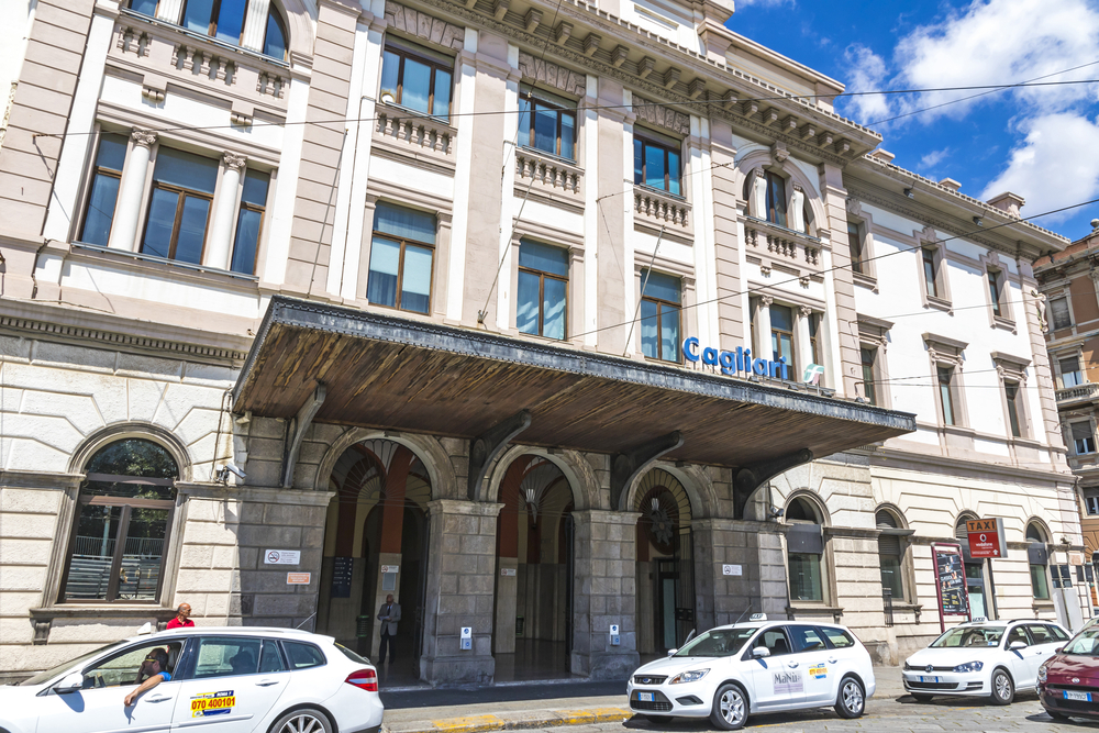 La fachada de la estación de tren de Cagliari con taxis delante de la entrada