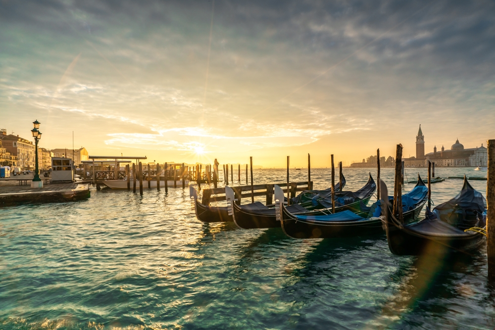Góndolas amarradas en el muelle de Venecia al atardecer
