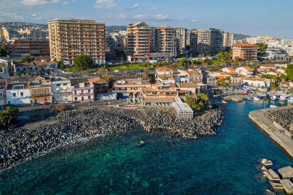El pequeño puerto y la playa de lava negra de San Giovanni li Cuti en Catania