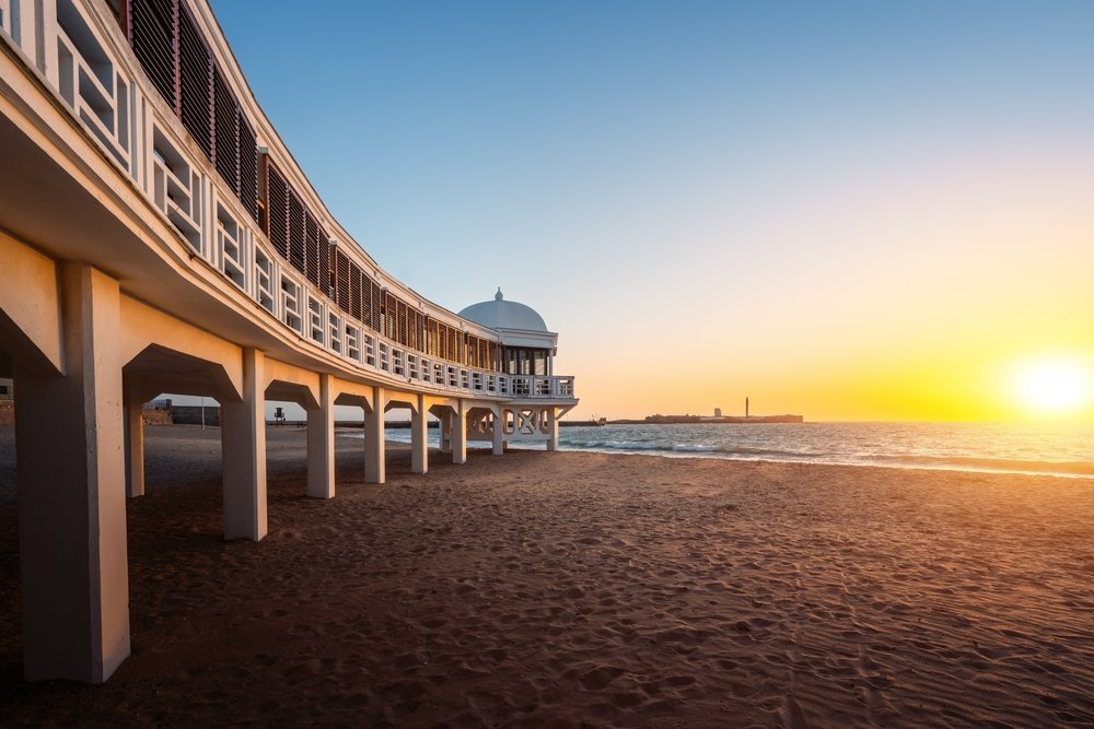 ¿Dónde alojarse en Cádiz? Las 5 mejores zonas y buenos hoteles 10 Playa de La Caleta en Cádiz con el balneario Balneario de la Palma al atardecer