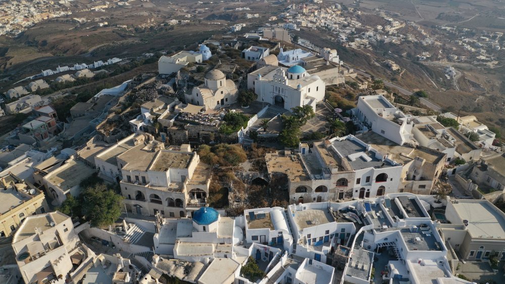 Qué ver en Santorini: 18 cosas que hacer, de la puesta de sol en Oia a las playas volcánicas 31 Pyrgos y el castillo en lo alto de la colina vistos desde el aire