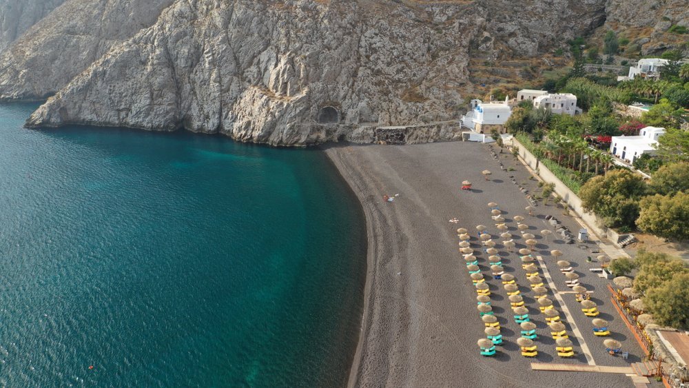 Qué ver en Santorini: 18 cosas que hacer, de la puesta de sol en Oia a las playas volcánicas 35 Vista aérea del pueblo de Kamari y su playa con tumbonas