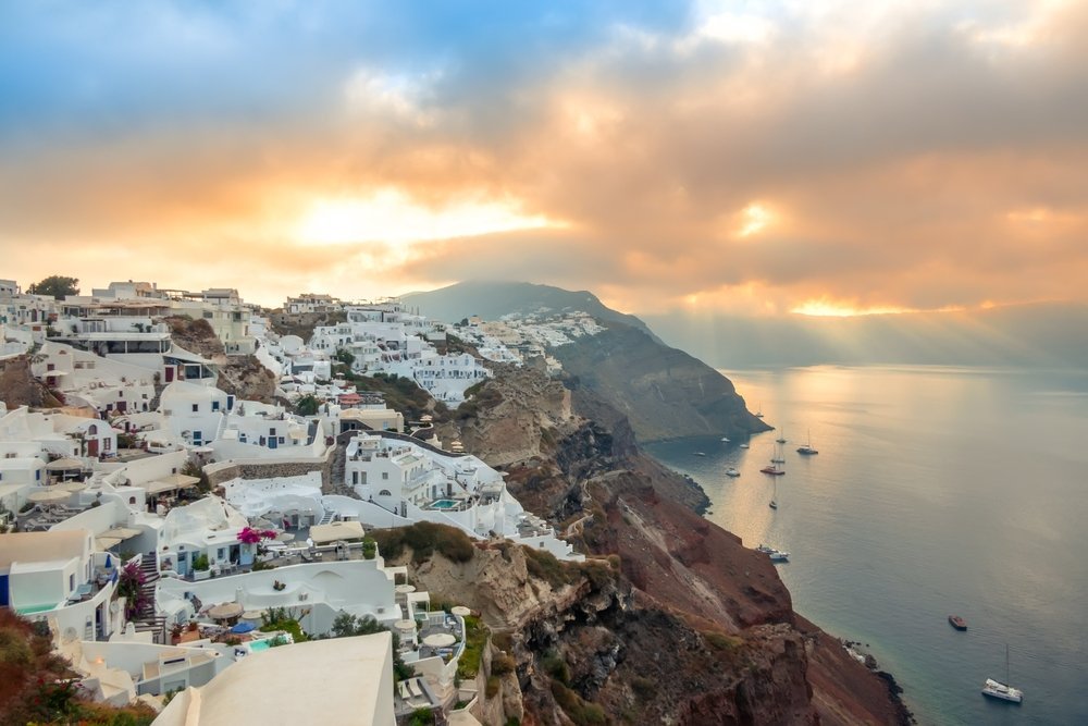 Qué ver en Santorini: 18 cosas que hacer, de la puesta de sol en Oia a las playas volcánicas 29 yates y catamaranes fondeados bajo Oia al amanecer